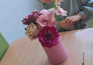 Dzieci samodzielnie tworzą kompozycje ze sztucznych kwiatów