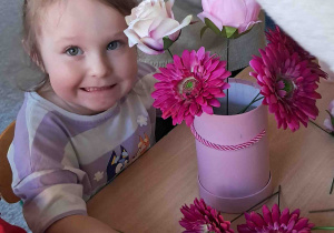 Dzieci samodzielnie tworzą kompozycje ze sztucznych kwiatów