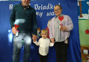 Chłopiec stoi na tle dekoracji z babcią i dziadkiem