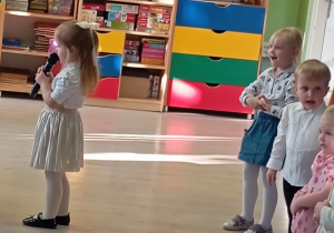 Dziewczynka w białej spódniczce mówi wiersz