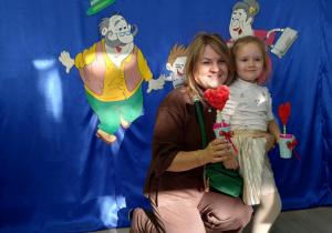 Dziewczynka w białej spódniczce robi sobie zdjęcie z babcią