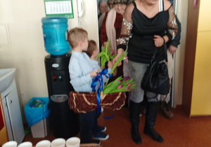 dzieci witają gości symbolicznym kwiatkiem