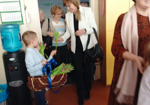 dzieci witają gości symbolicznym kwiatkiem