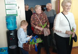 dzieci witają gości symbolicznym kwiatkiem