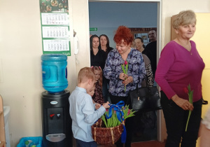 dzieci witają gości symbolicznym kwiatkiem