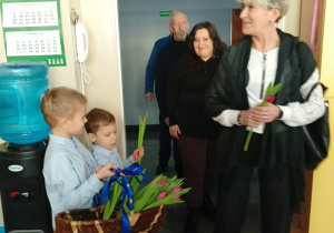 dzieci witają gości symbolicznym kwiatkiem