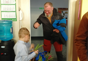 dzieci witają gości symbolicznym kwiatkiem