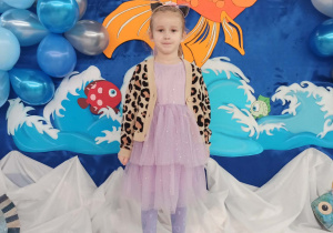 Dziewczynka pozuje do zdjęcia na tle dekoracji