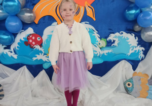 Dziewczynka pozuje do zdjęcia na tle dekoracji