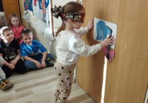 Dziewczynka próbuje doczepić ogon Kłapouchemu