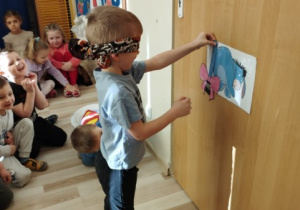 Chłopiec próbuje doczepić ogon Kłapouchemu