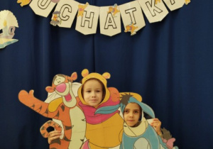 Dziewczynki trzymają fotobudkę i pozują do zdjęcia