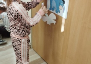 Dziewczynka próbuje doczepić ogon Kłapouchemu