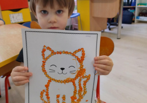 Chłopiec trzyma pracę kota.