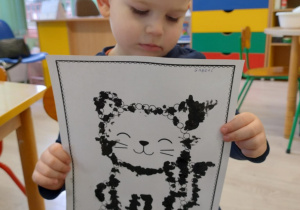 Chłopiec trzyma w ręku wykonaną pracę.