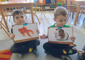 Chłioec trzyma grafikę rybki, obok chłioec trzyma grafikę chomika