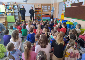 Dzieci słuchają prelekcji strażaków