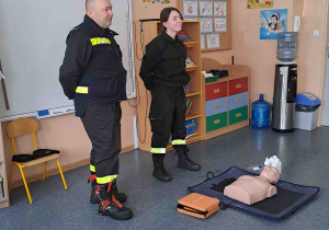 Dzieci słuchają prelekcji strażaków