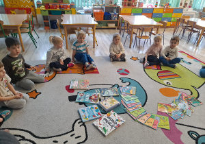 Dzieci siedzą w kole wokół książek