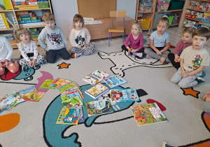 Dzieci siedzą w kole i słuchają nauczycielki