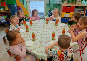 Dzieci pozują do zdjęcia przy stole.