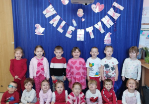 Dzieci pozują do zdjęcia na tle dekoracji.