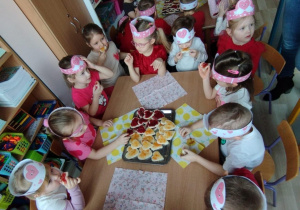 Dzieci jedzą słodki poczęstunek.