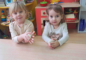 Dzieci przy stoliku wygniatają masę solną