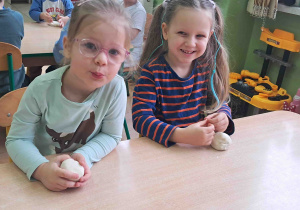 Dzieci przy stoliku wygniatają masę solną