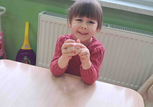 Dzieci przy stoliku wygniatają masę solną