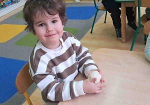 Dzieci przy stoliku wygniatają masę solną