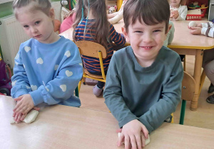 Dzieci wałkują przy stoliku masę solną