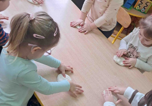 Dzieci wałkują masę solną na stołach