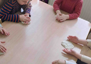 Dzieci wałkują masę solną na stołach