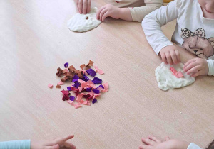 Dzieci umieszczają nadzienie z bibuły w swoich pączkach