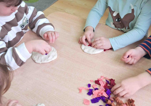 Dzieci umieszczają nadzienie z bibuły w swoich pączkach