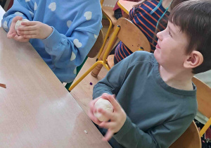 Dzieci umieszczają nadzienie z bibuły w swoich pączkach