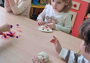 Dzieci umieszczają nadzienie z bibuły w swoich pączkach