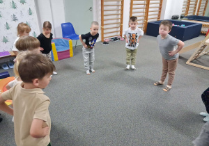 Dzieci stoją w kole i ćwiczą mięśnie stóp.