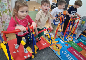 Dzieci ćwiczą na sprzęcie gimnastycznym.