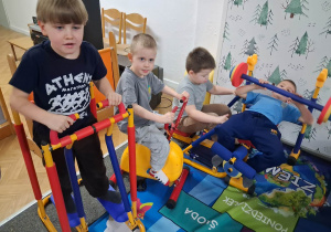 Dzieci ćwiczą na sprzęcie gimnastycznym.