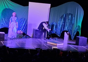 Scena z dekoracją do spektaklu Smocze opowieści. Aktorzy występują.