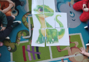 Dzieci ułożyły obrazek dinozaura pocięty na części