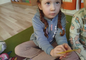 Dziewczynka podaje wylosowaną karteczkę