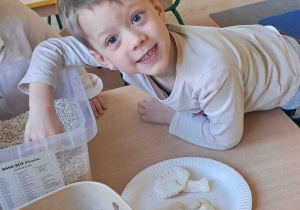 Dzieci wyszukują kości dinozaurów w kaszy, ryżu