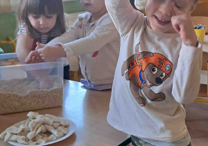 Dzieci wyszukują kości dinozaurów w kaszy, ryżu