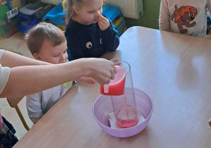 Dzieci obserwują eksperyment wulkan przy stoliku