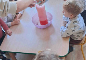 Dzieci obserwują eksperyment wulkan przy stoliku