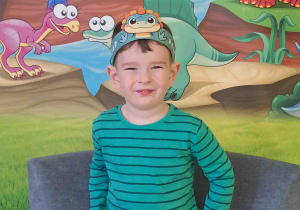 Dzieci pozują na tle dekoracji Dnia Dinozaura