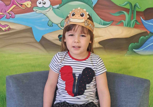 Dzieci pozują na tle dekoracji Dnia Dinozaura